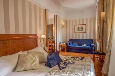 a bedroom with a bed and a blue couch at Albergo Ottocento in Rome