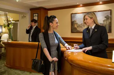 two women standing at a reception desk at Albergo Ottocento in Rome