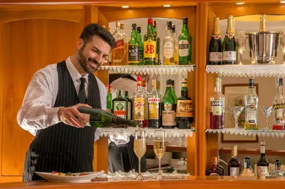 a man pouring a glass of wine in a bar at Albergo Ottocento in Rome
