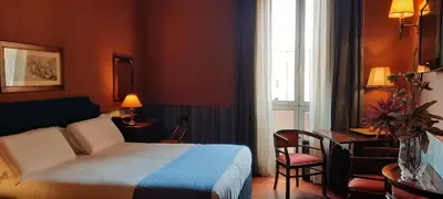 a hotel room with a bed and a desk and a window at Domus Livia in Rome
