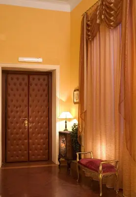 a room with a door and a chair and a lamp at Domus Livia in Rome