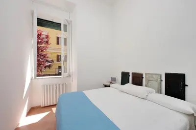 a white bedroom with a bed and a window at 4BNB - Quiriti Delightful Apartment in Rome