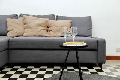 two wine glasses on a table in front of a couch at 4BNB - Quiriti Delightful Apartment in Rome