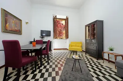 a living room with a dining room table and chairs at 4BNB - Quiriti Delightful Apartment in Rome