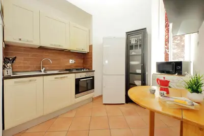 a kitchen with a white refrigerator and a table at 4BNB - Quiriti Delightful Apartment in Rome