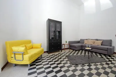 a living room with a couch and a yellow chair at 4BNB - Quiriti Delightful Apartment in Rome