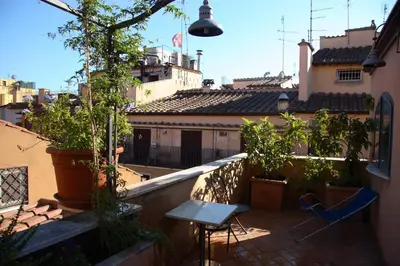 a balcony with plants and a table and chairs at Hotel Piazza Di Spagna in Rome