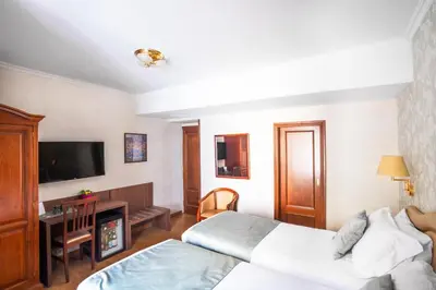 a hotel room with two beds and a flat screen tv at Hotel Piazza Di Spagna in Rome