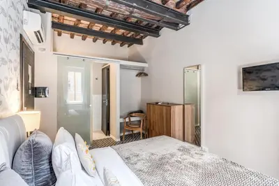 a bedroom with a white bed and a desk at Trevi Beau Boutique Hotel in Rome