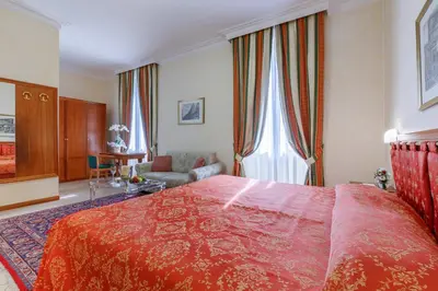 a bedroom with a large red bed and a couch at Residenza Paolo VI in Rome