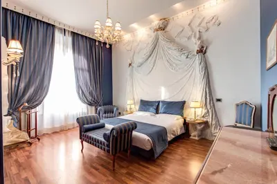 a bedroom with a bed and a chair at Hotel Impero in Rome