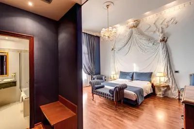 a bedroom with a bed and a chair at Hotel Impero in Rome