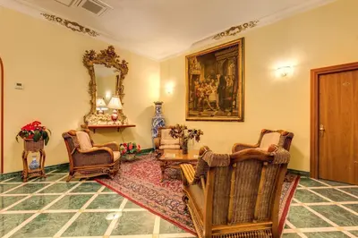 a living room with chairs and a table and a mirror at Hotel Impero in Rome