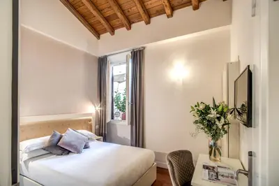a hotel room with a bed and a table at Hotel San Silvestro in Rome
