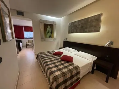 a bedroom with a bed with two red pillows on it at Hotel De Petris in Rome