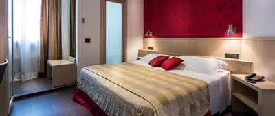 a hotel room with a bed with two red pillows at Hotel De Petris in Rome