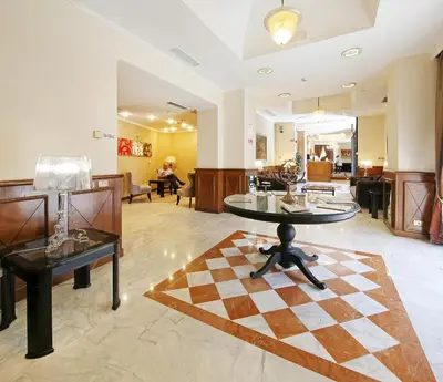 a lobby with a table and a checkerboard floor at Hotel Traiano in Rome