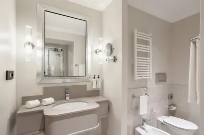 a white bathroom with a sink and a toilet at Room Mate Collection Mia, Rome Colosseum in Rome