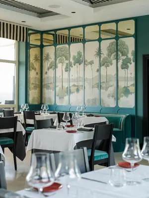 a dining room with tables and chairs and a painting on the wall at Room Mate Collection Mia, Rome Colosseum in Rome