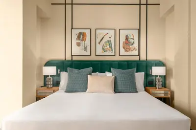 a bedroom with a large bed with a green headboard at Room Mate Collection Mia, Rome Colosseum in Rome