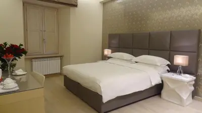 a bedroom with a large bed with a large headboard at Augustana House and Suites in Rome