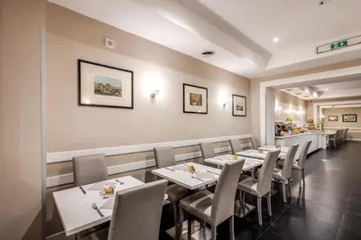 a dining room with white tables and chairs at Hotel Villafranca in Rome