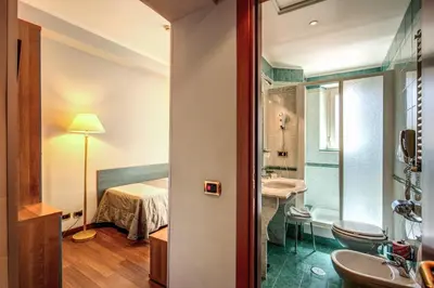 a bathroom with a sink and a bed in a room at Hotel Villafranca in Rome