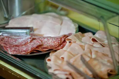 a display case with meat and ham in a store at Hotel Patria in Rome