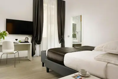 a hotel room with a bed and a desk and a television at Hotel Patria in Rome