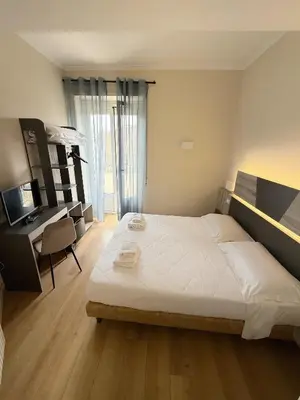 a bedroom with a large bed with a desk and a computer at Hotel Laura in Rome