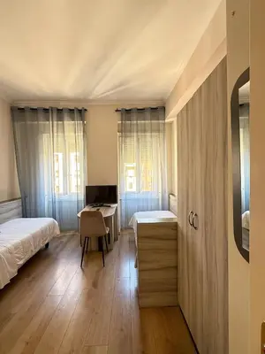 a bedroom with two beds and a desk in it at Hotel Laura in Rome