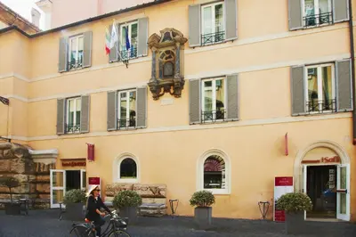 a woman riding a bike in front of a building at Hotel Indigo Rome - St. George by IHG in Rome