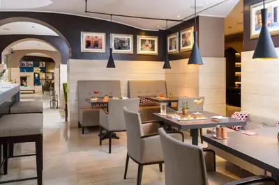 a restaurant with tables and chairs and portraits on the wall at Hotel Indigo Rome - St. George by IHG in Rome
