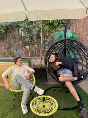 a man and a woman sitting in chairs under an umbrella at Free Hostels Roma in Rome