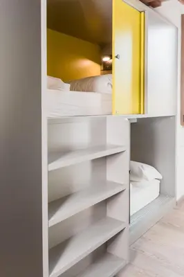 a closet with white shelves and a bed at Free Hostels Roma in Rome