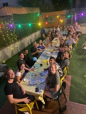 a group of people sitting at long tables at Free Hostels Roma in Rome