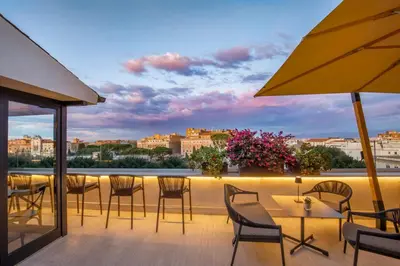 a balcony with tables and chairs and a view of a city at The Guardian in Rome