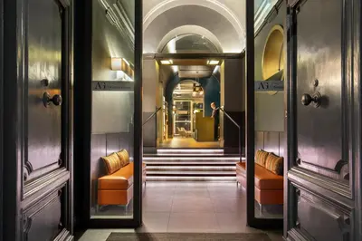 a hallway with orange chairs and stairs in a building at The Guardian in Rome