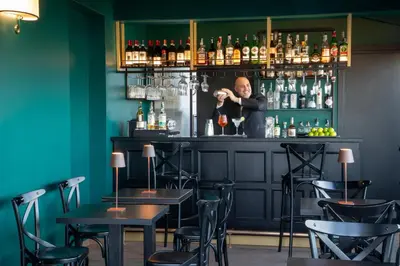 a man standing behind a bar in a restaurant at The Guardian in Rome