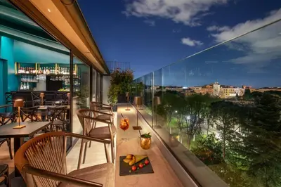 a balcony with tables and chairs and a view of a city at The Guardian in Rome