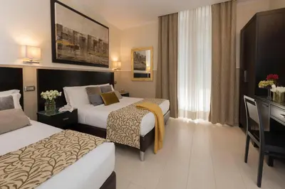 a hotel room with two beds and a desk at Yes Hotel Boutique Rome in Rome