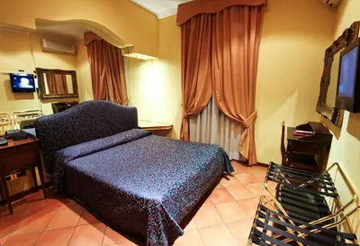 a bedroom with a blue bed and a television at Hotel Canova in Rome
