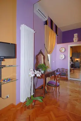 a living room with a table and a mirror at Suite Casa Pariolina in Rome