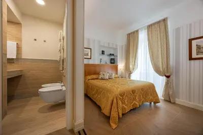 a bedroom with a bed and a bathroom with a toilet at Residenza RomaCentro in Rome