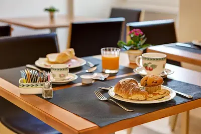 a table with a plate of bread and orange juice at Residenza RomaCentro in Rome