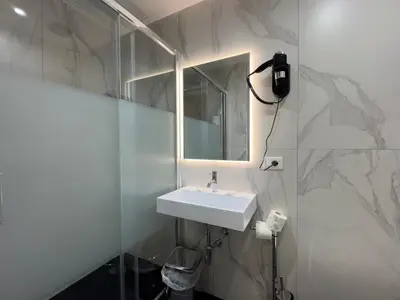a white bathroom with a sink and a mirror at Hotel Philia in Rome