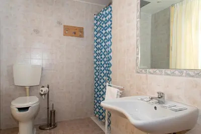 a bathroom with a sink and a toilet and a mirror at Hotel Philia in Rome