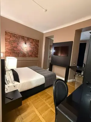 a hotel room with a bed and a television at Relais Fontana Di Trevi Hotel in Rome