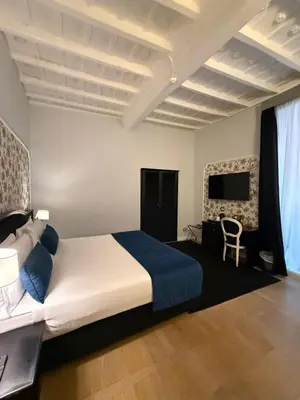 a bedroom with a large bed and a television at Relais Fontana Di Trevi Hotel in Rome