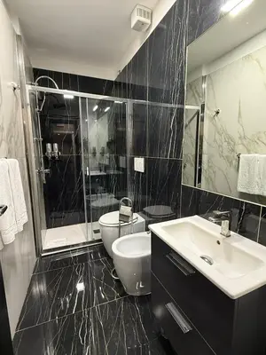 a black and white bathroom with a toilet and a sink at Relais Fontana Di Trevi Hotel in Rome